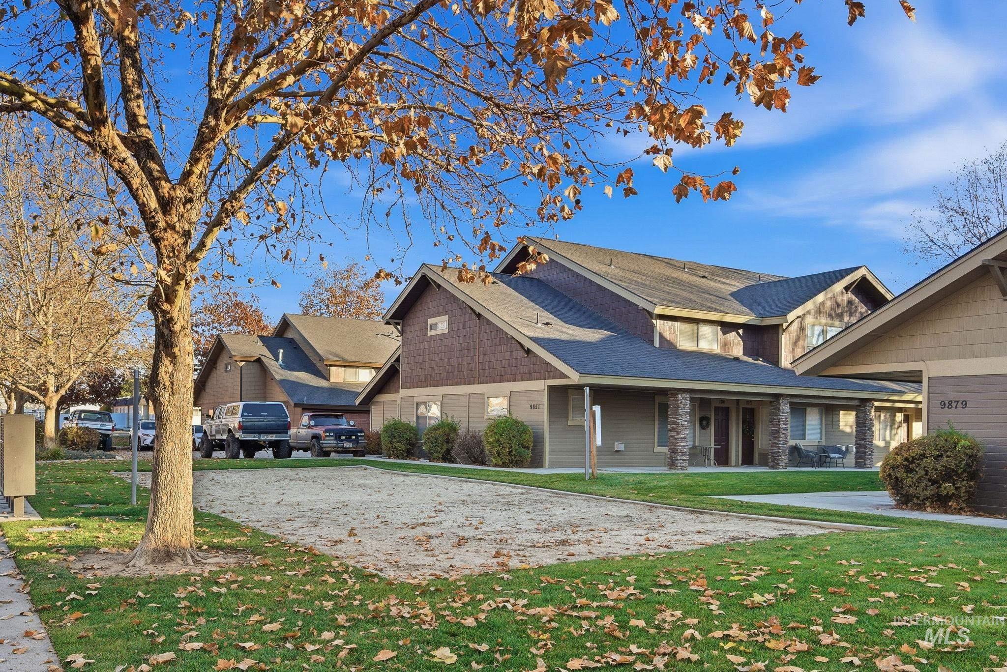View of property exterior with a yard, a porch, and stone siding