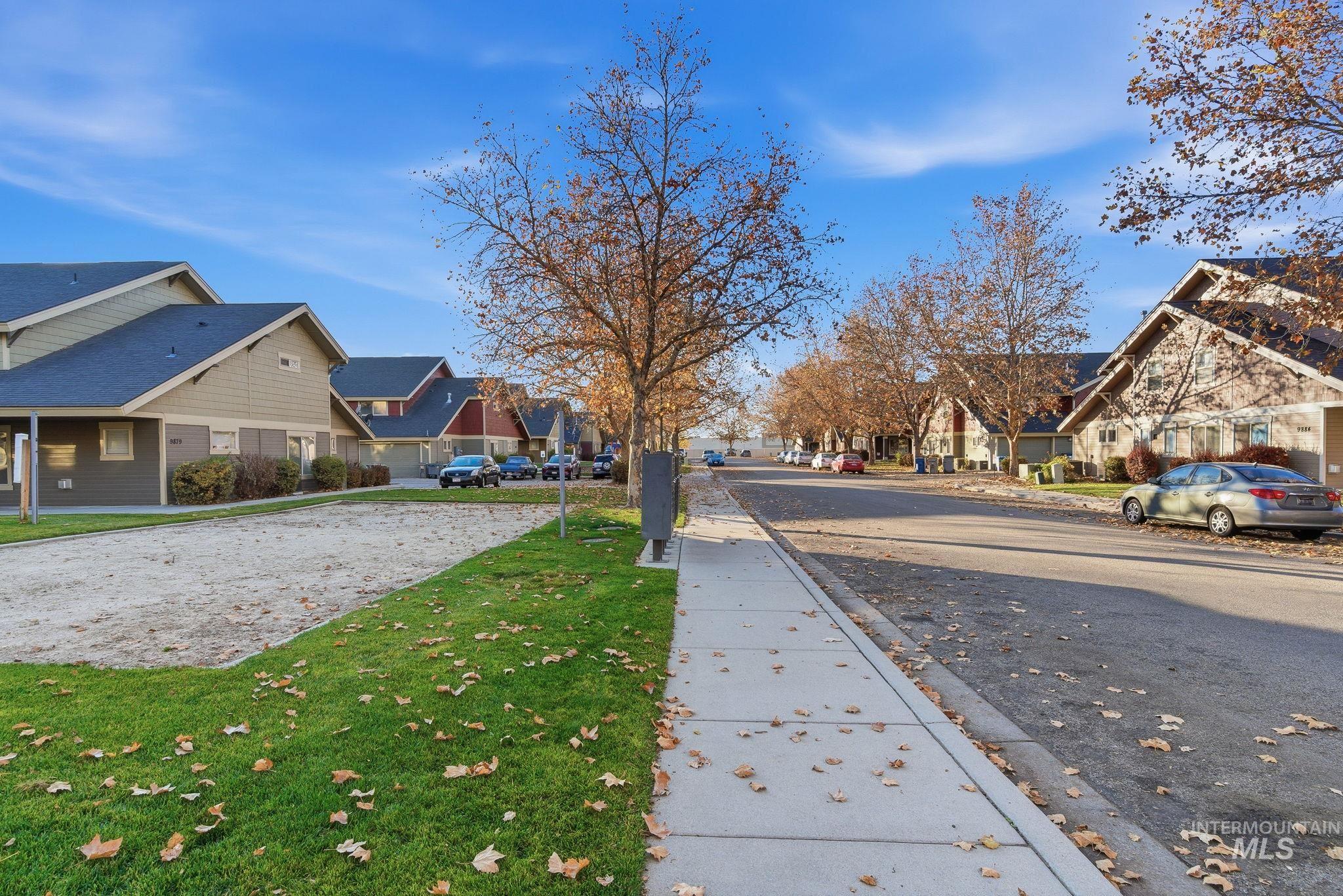 View of asphalt street with a residential view, curbs, and sidewalks
