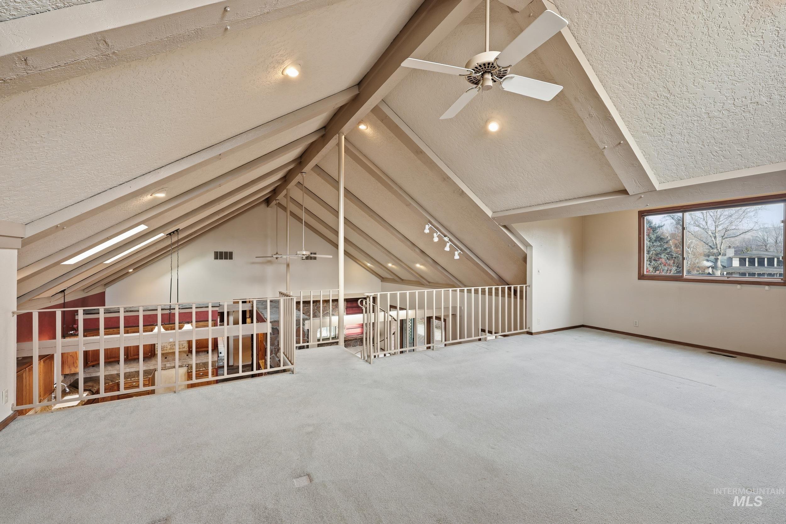Bonus room with a ceiling fan, a textured ceiling, and carpet