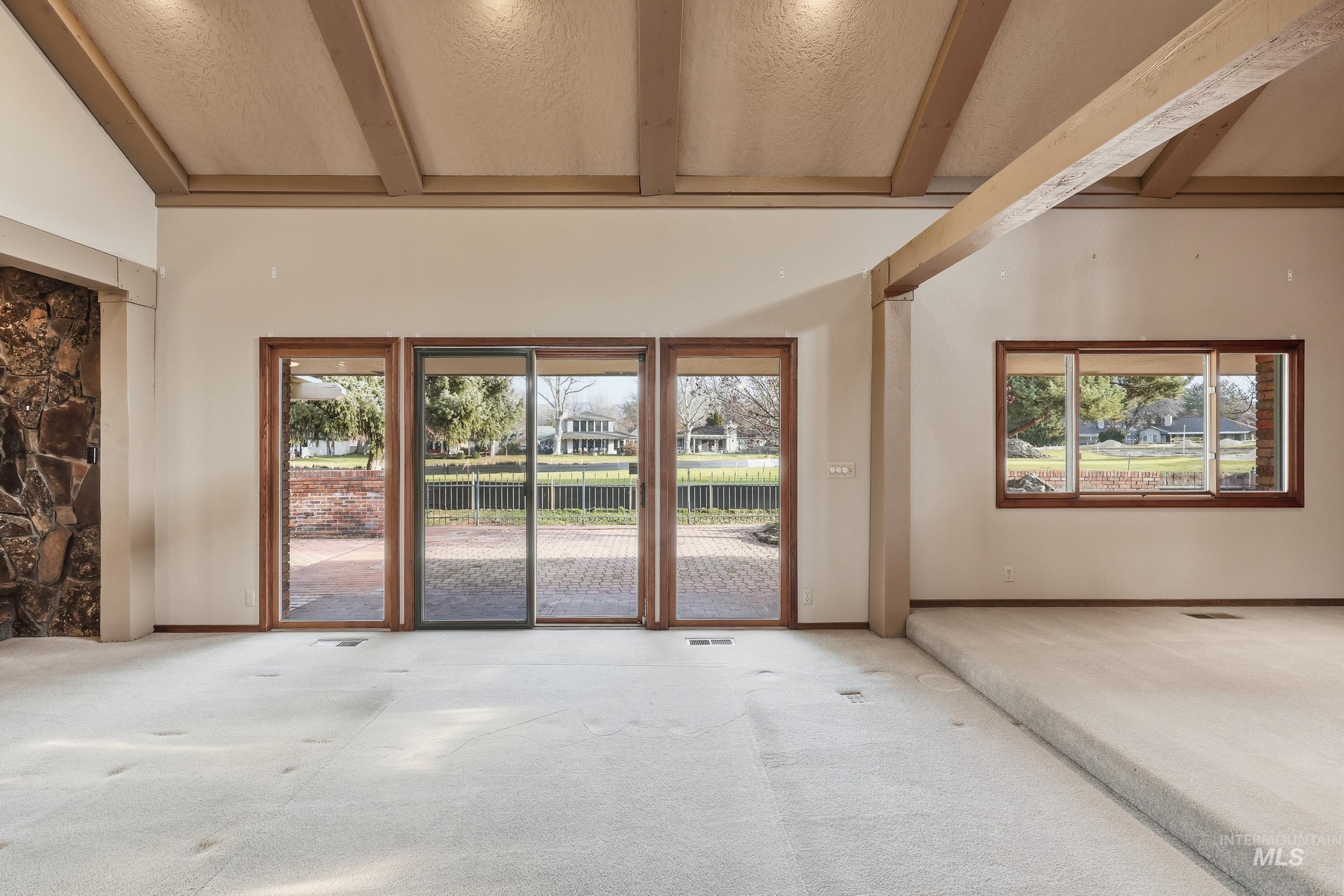 Carpeted spare room with a textured ceiling and healthy amount of natural light