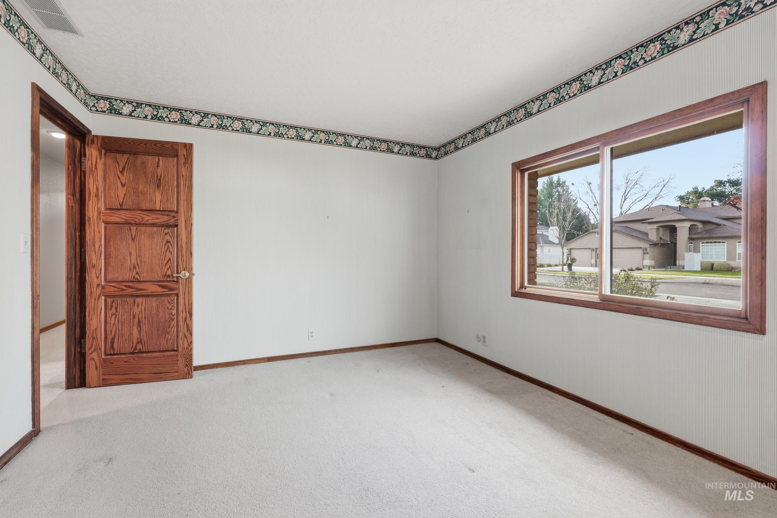 Unfurnished room with light colored carpet and baseboards