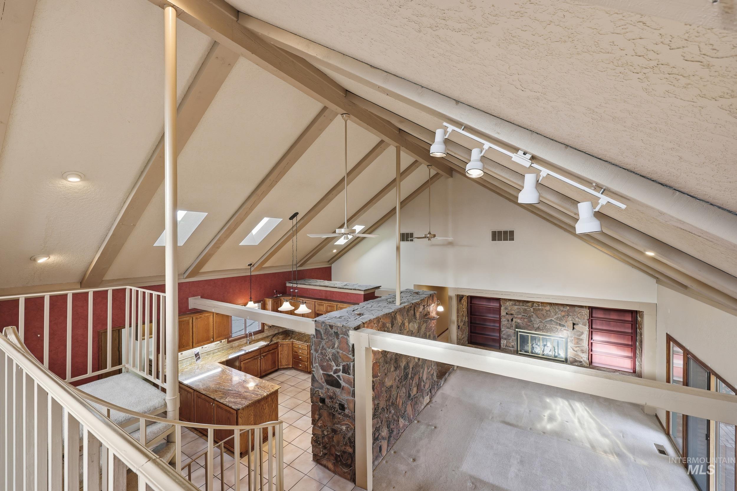 Interior space with track lighting, a skylight, and light tile patterned floors