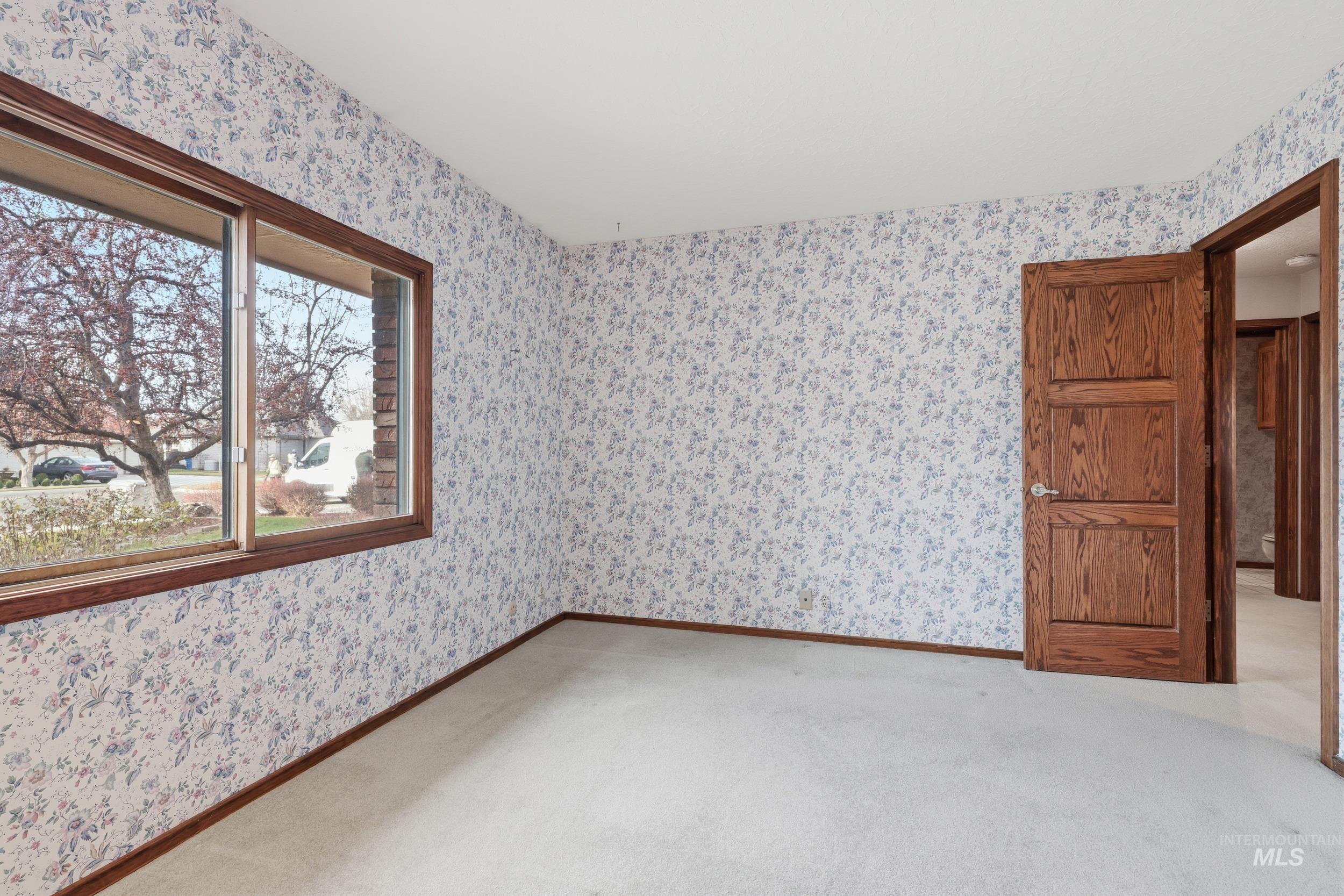 Unfurnished room with wallpapered walls and light colored carpet