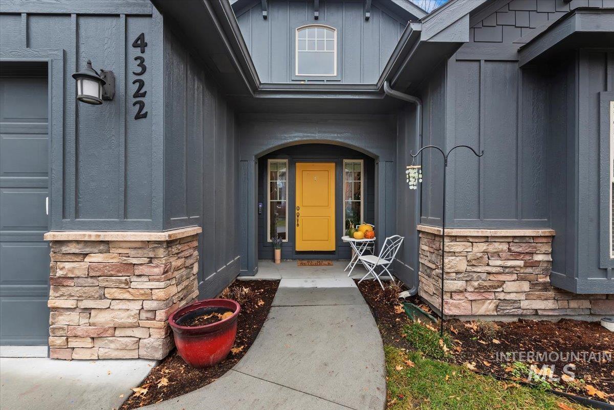 View of exterior entry featuring stone siding and board and batten siding