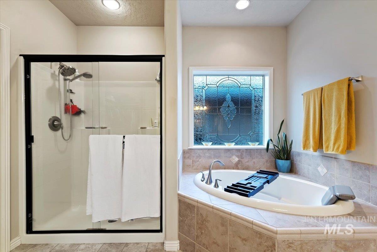 Full bathroom with a bath, a stall shower, and recessed lighting