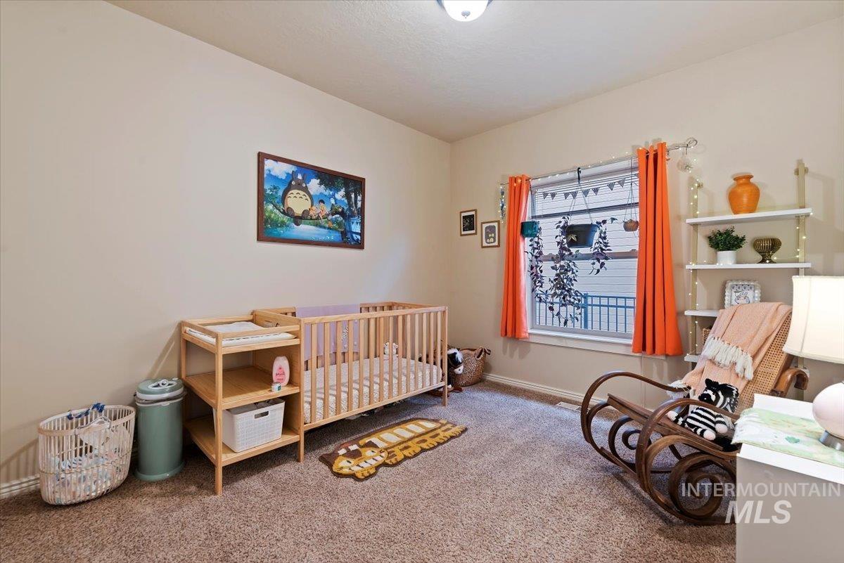 Bedroom with a nursery area and carpet floors