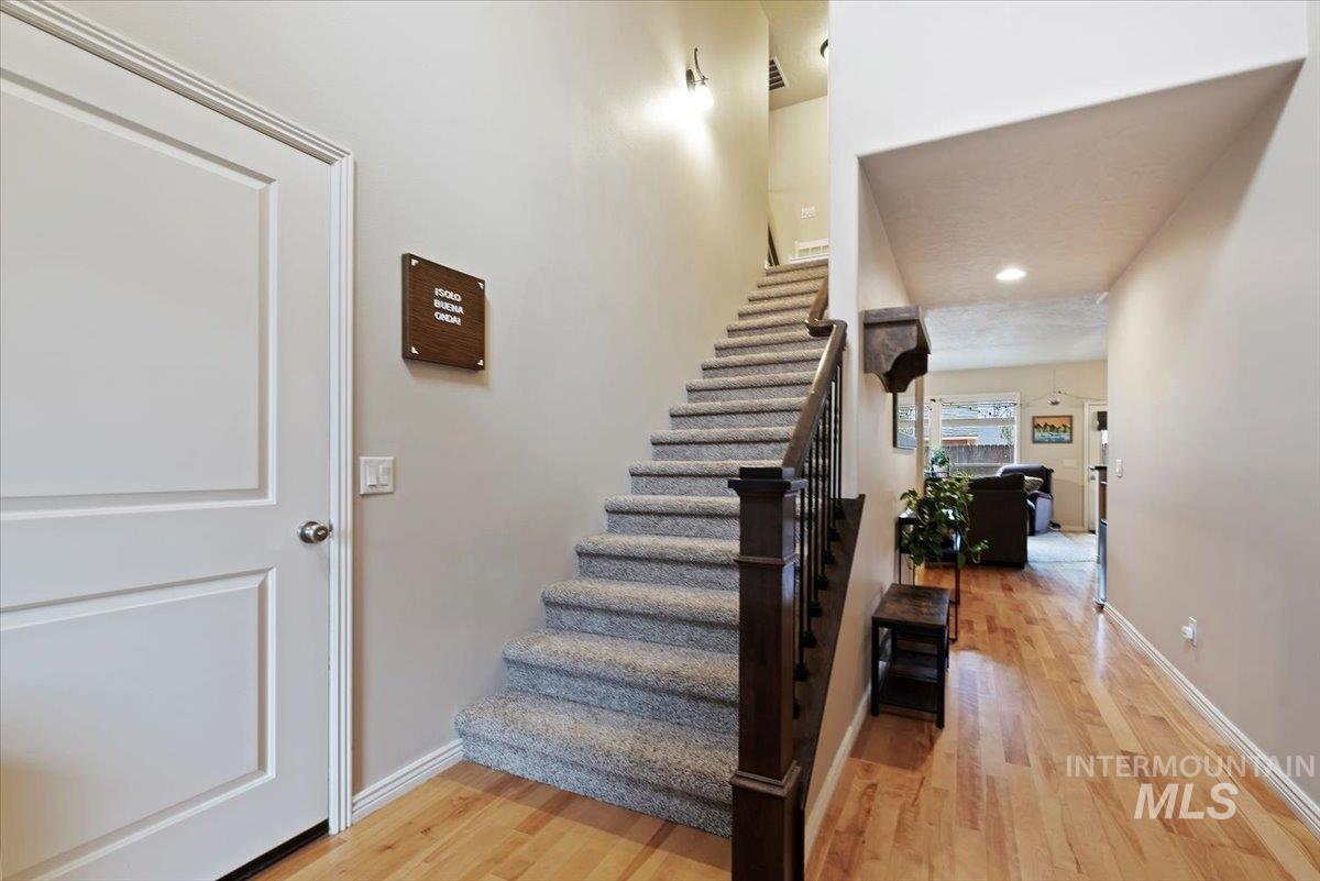 Stairway with wood finished floors and recessed lighting
