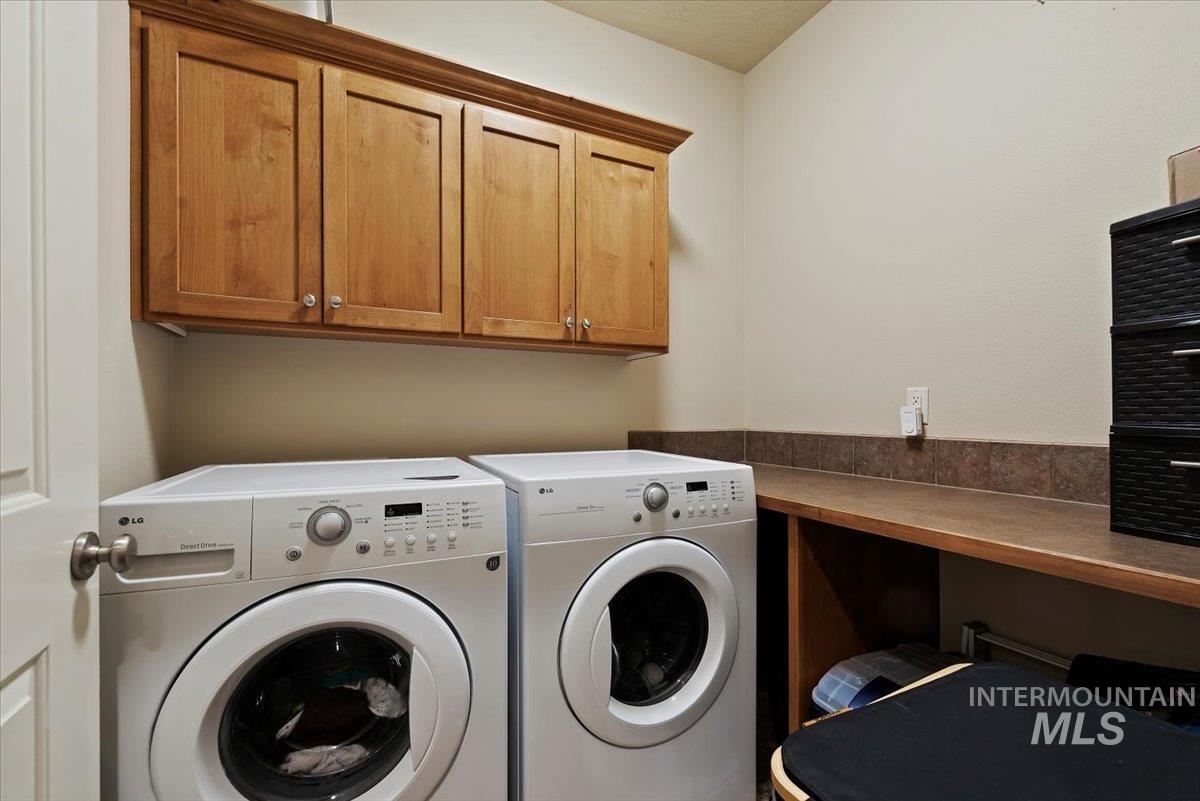Washroom featuring washing machine and clothes dryer and cabinet space
