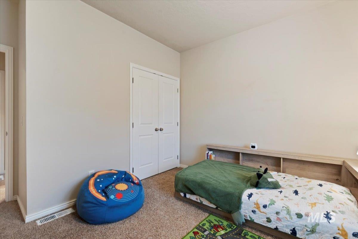 Carpeted bedroom with a closet and baseboards