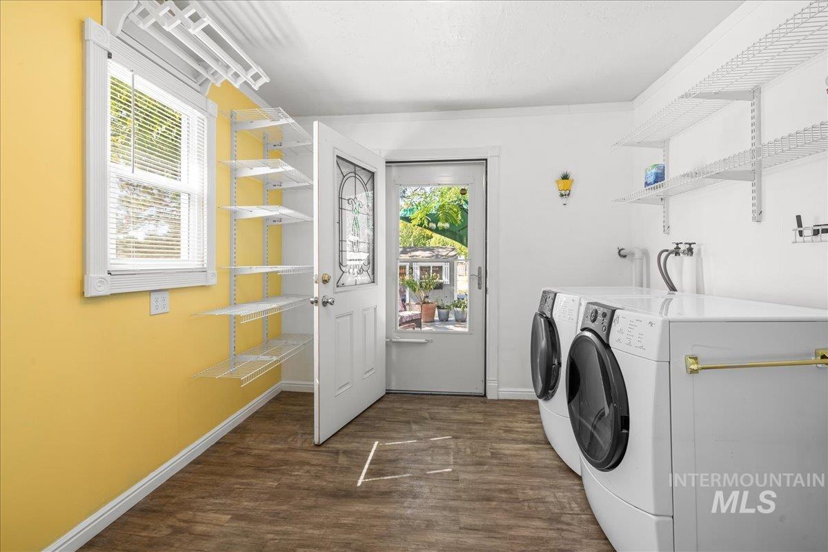 Washroom with dark wood-style floors and separate washer and dryer