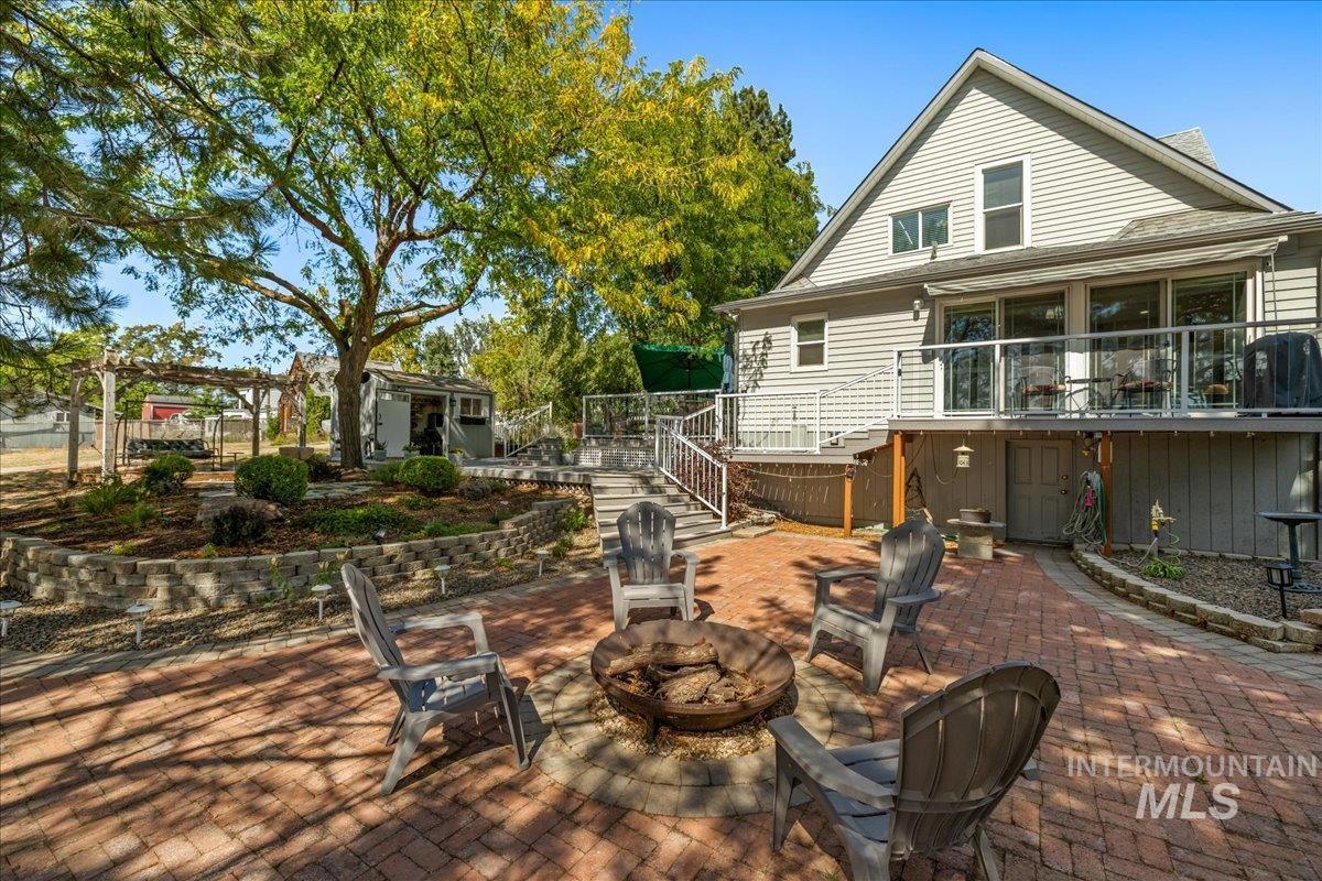 View of patio / terrace with stairway, an outdoor fire pit, an outdoor structure, and a deck
