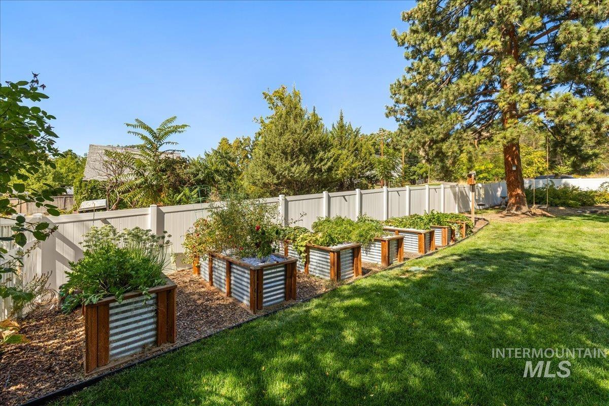 Fenced backyard featuring a garden