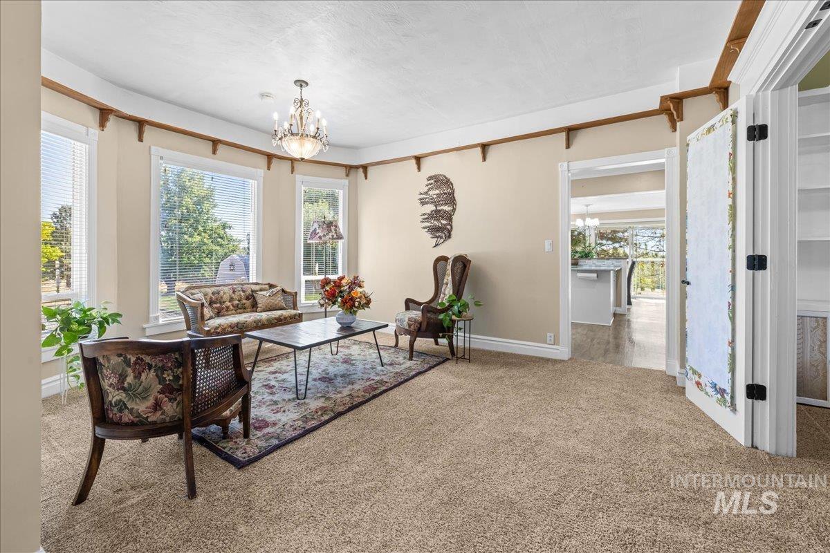 Carpeted sitting room with a chandelier and healthy amount of natural light