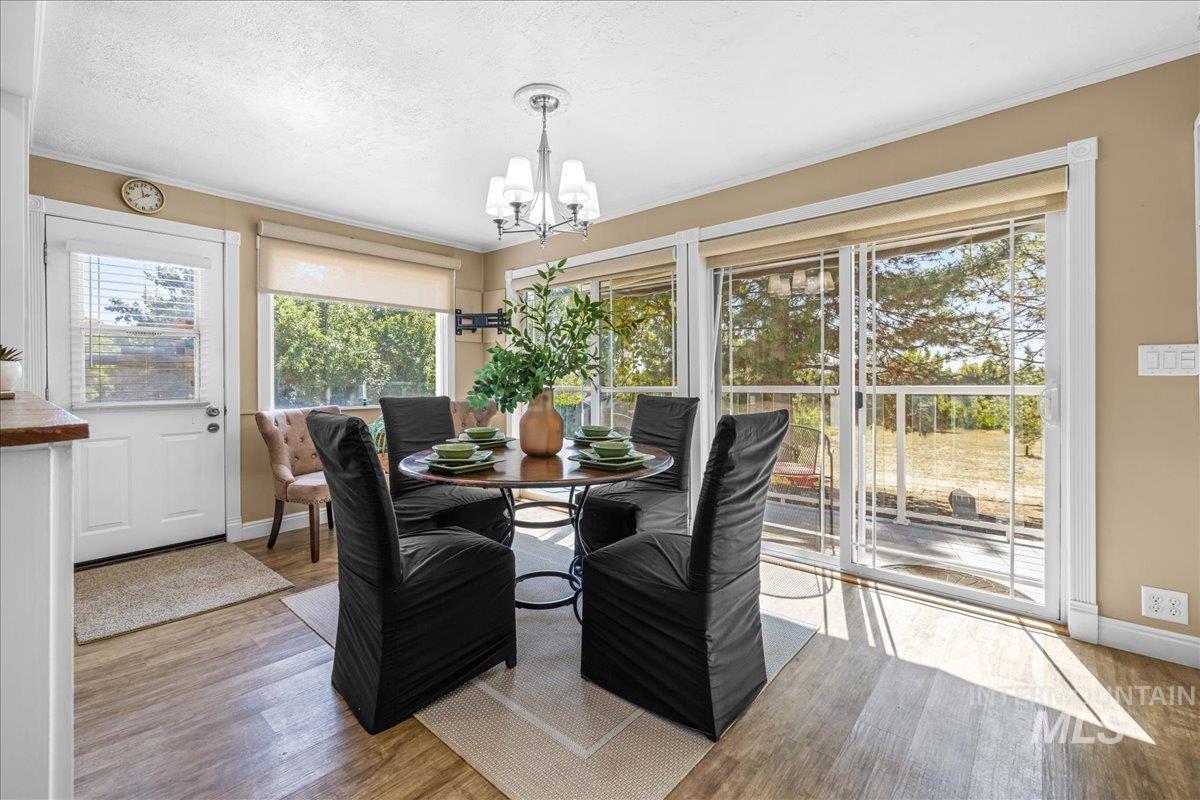 Dining space featuring light wood-style floors, a textured ceiling, and a chandelier