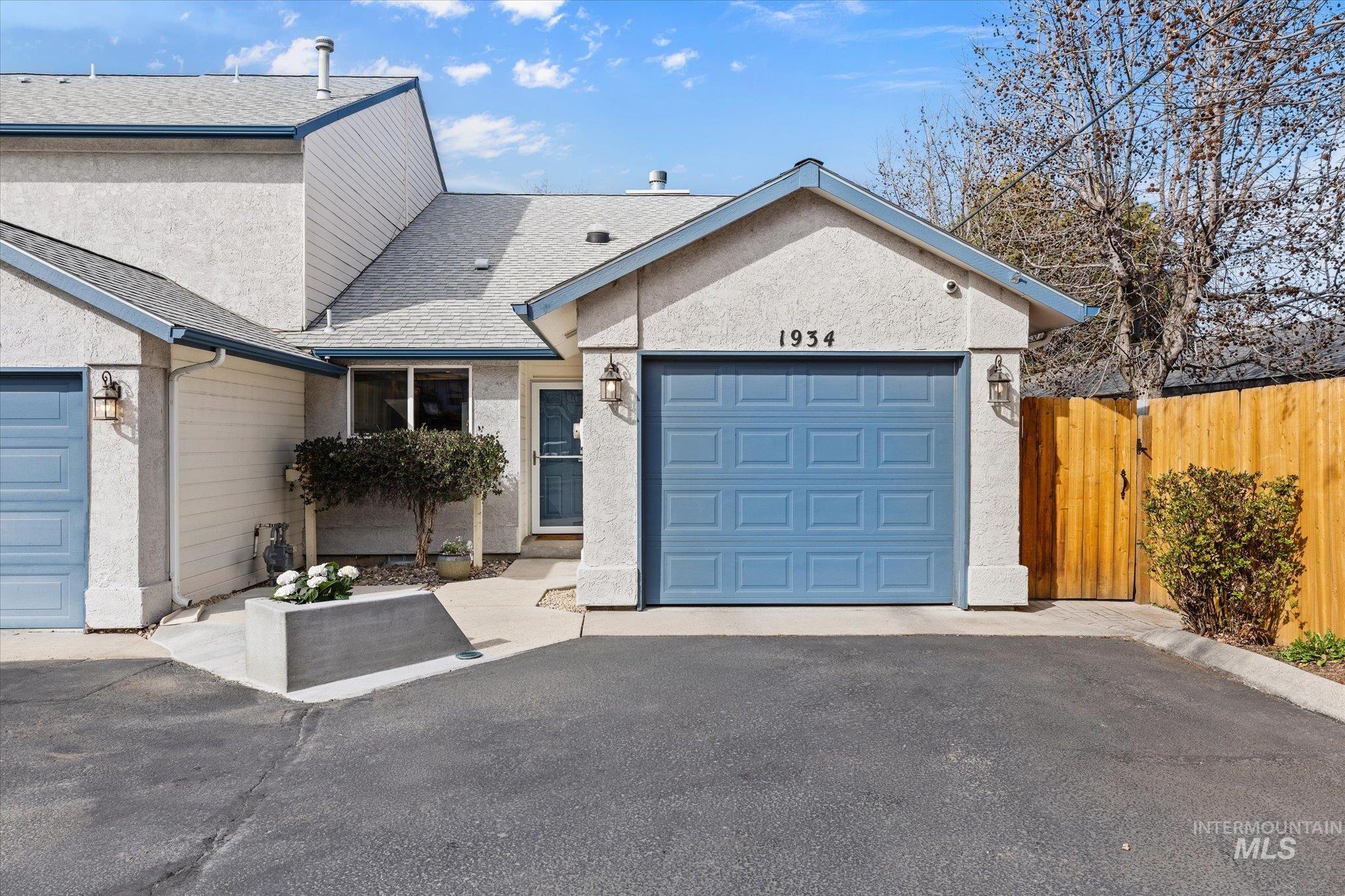 Single story home featuring roof with shingles, a garage, stucco siding, and asphalt driveway