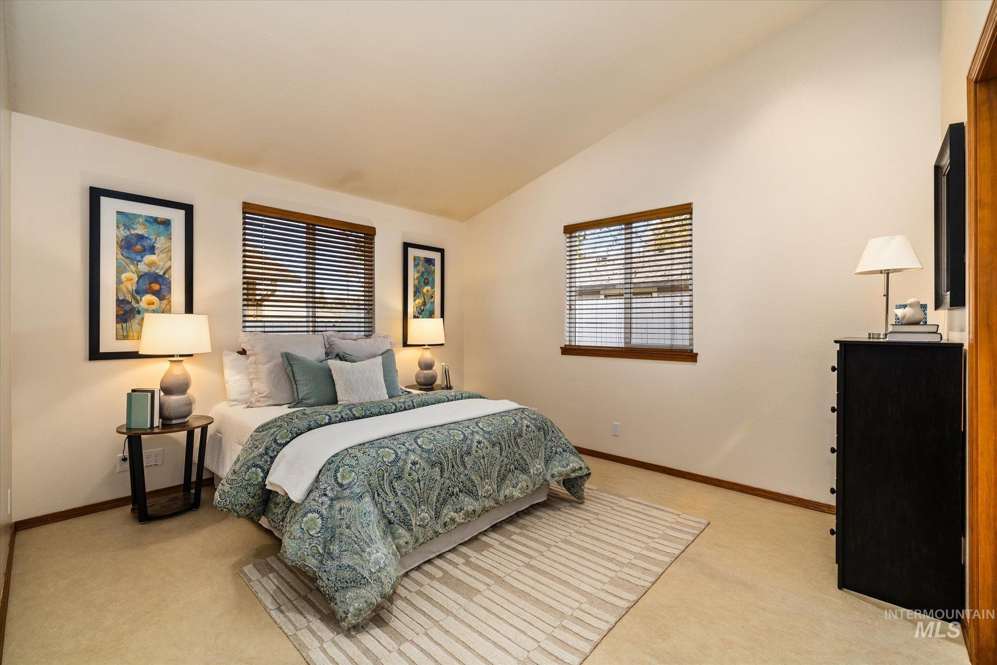 Bedroom featuring vaulted ceiling and light colored carpet