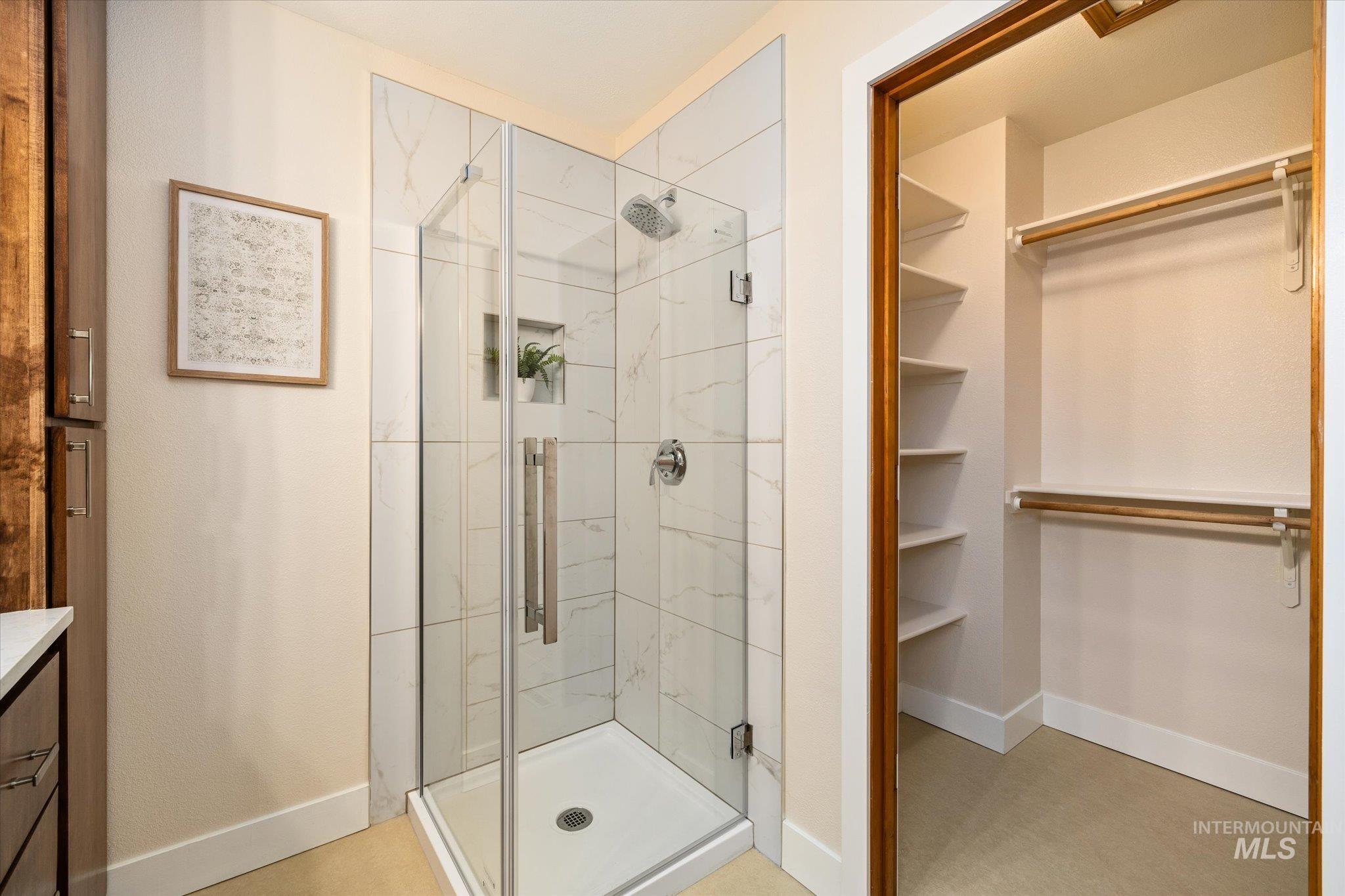 Full bathroom with a walk in closet, vanity, and a shower stall