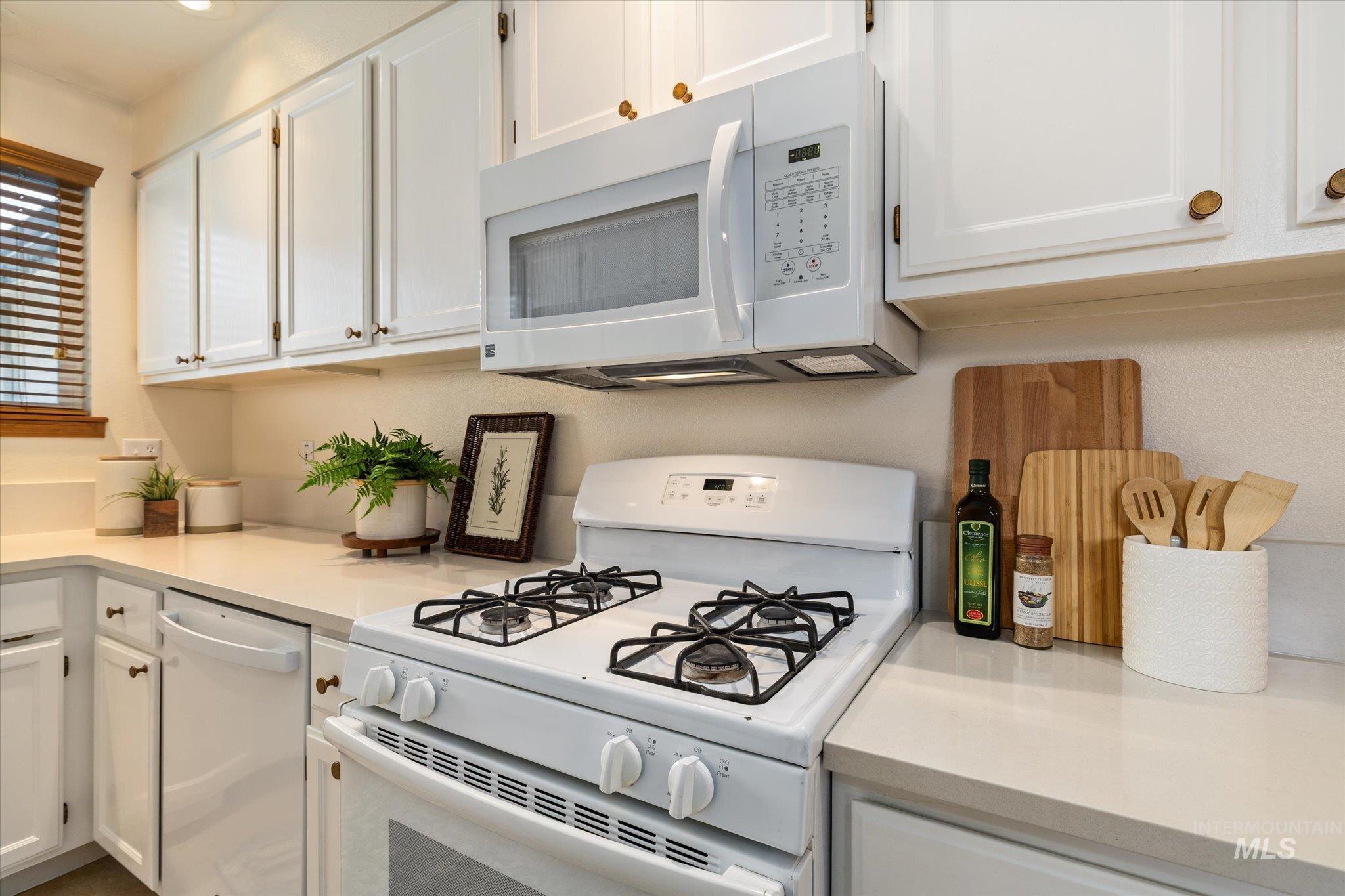 Kitchen featuring white appliances and white cabinetry