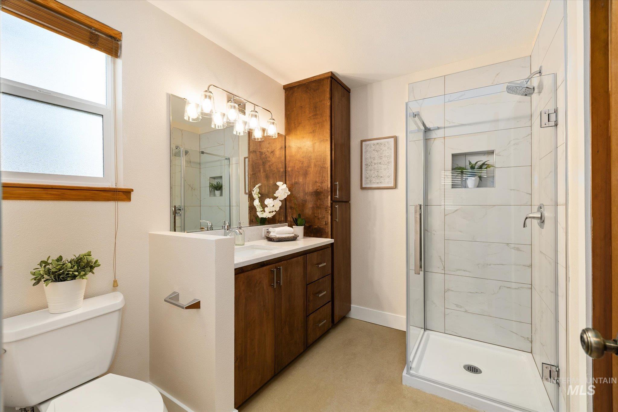 Full bath featuring vanity and a marble finish shower