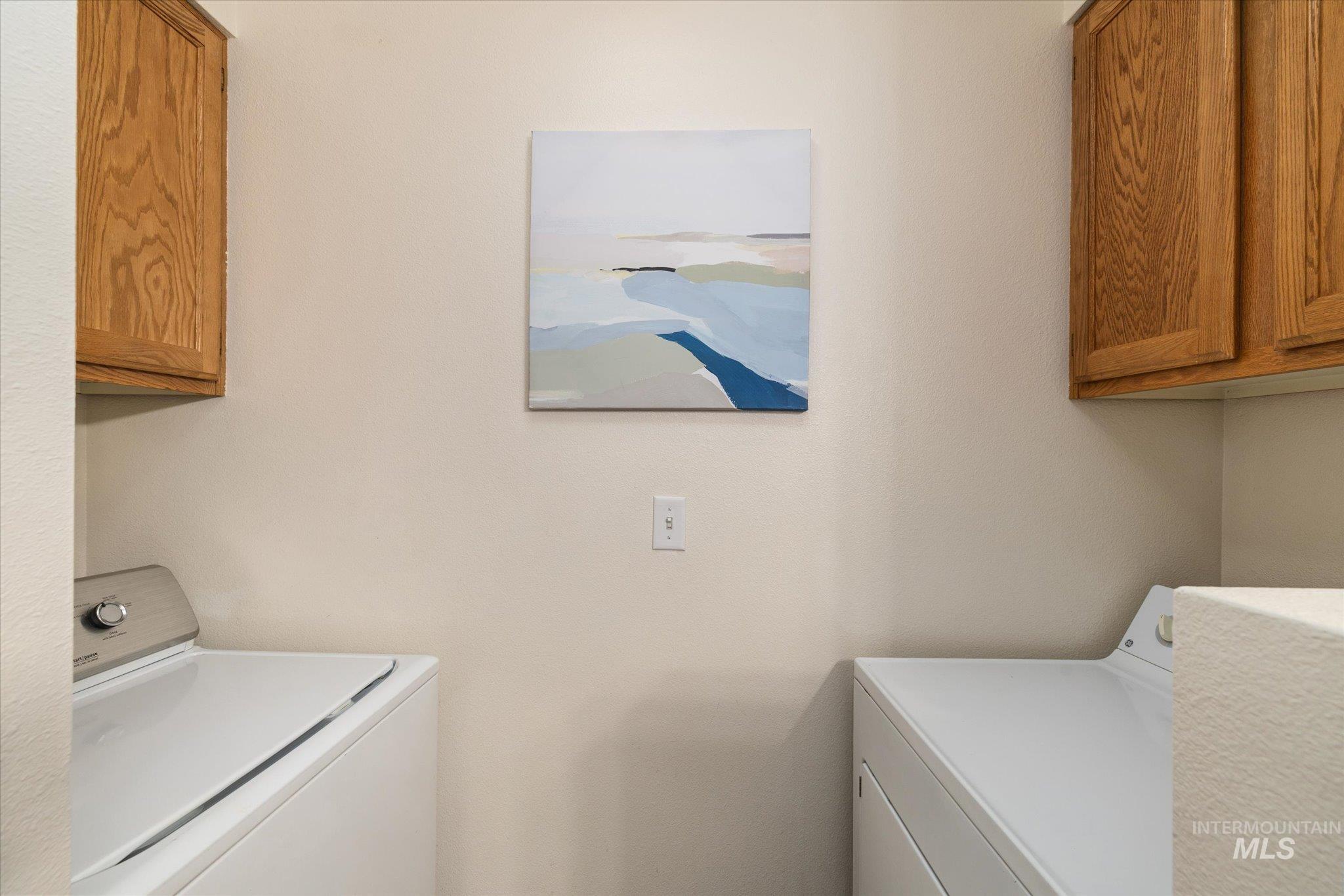 Laundry area with cabinet space and washing machine and clothes dryer