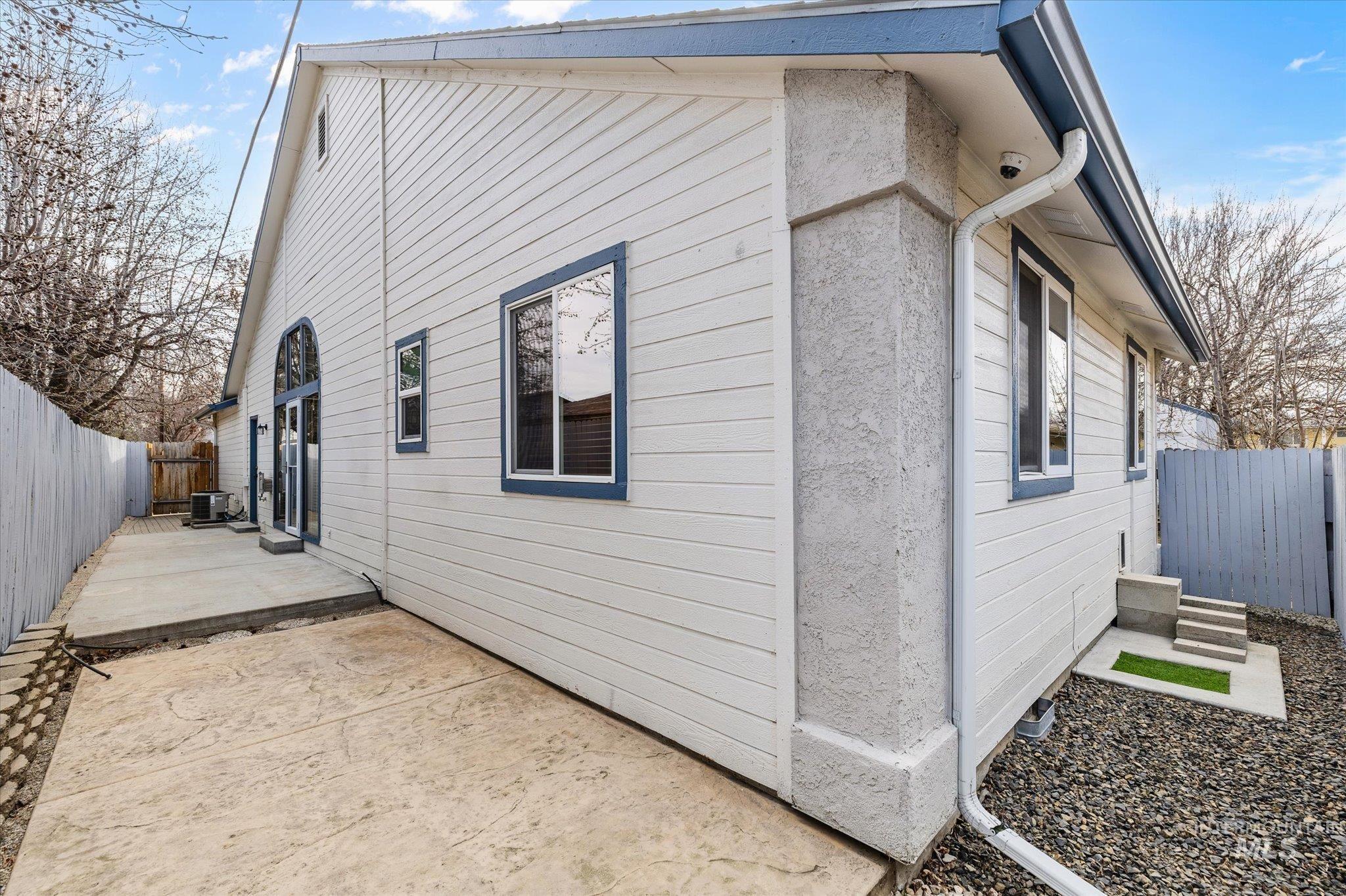 View of side of property with a fenced backyard and a patio
