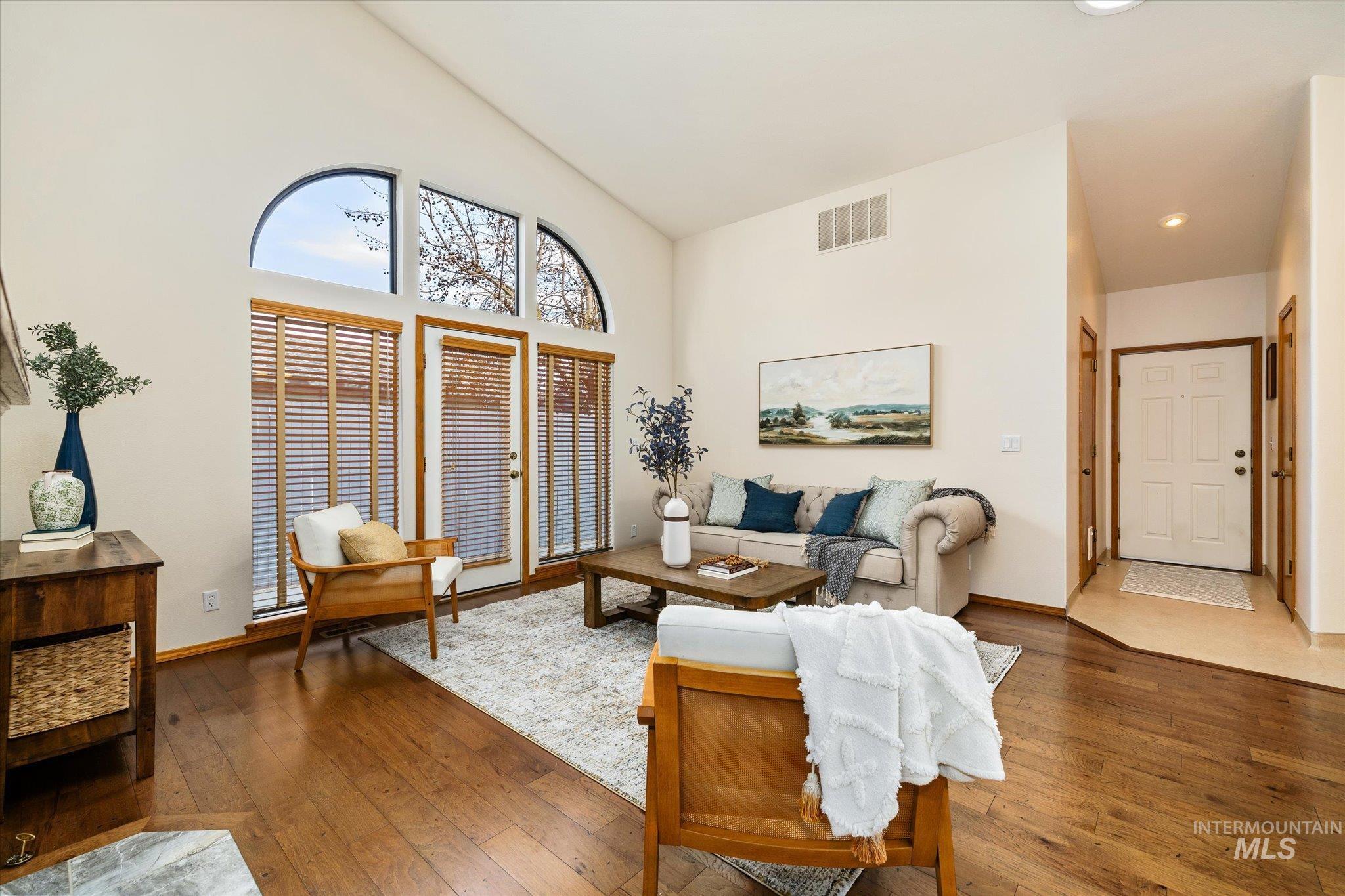 Living room featuring wood-type flooring and lofted ceiling