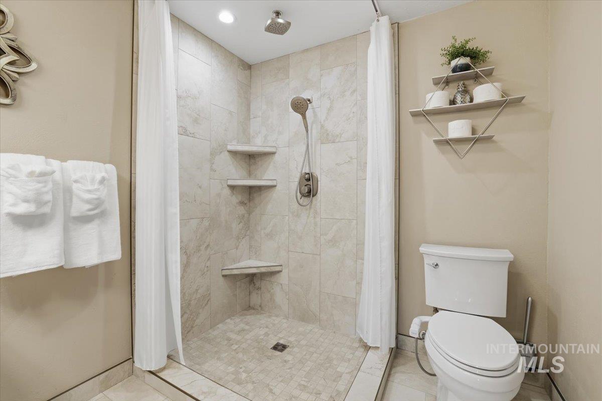 Bathroom featuring a stall shower and toilet