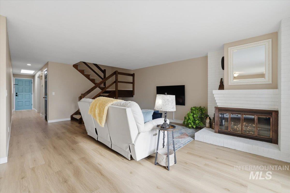 Bedroom featuring light wood-type flooring and a brick fireplace