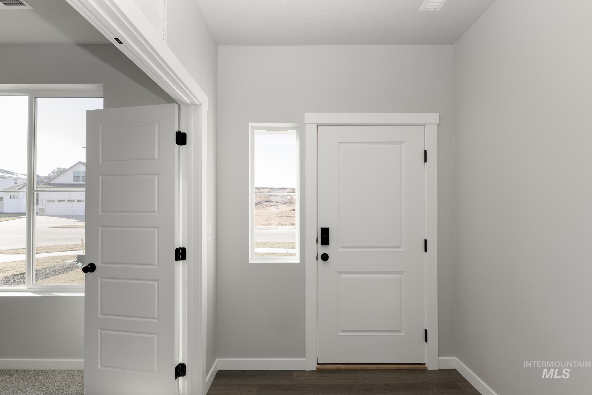 Doorway to outside featuring baseboards and wood finished floors