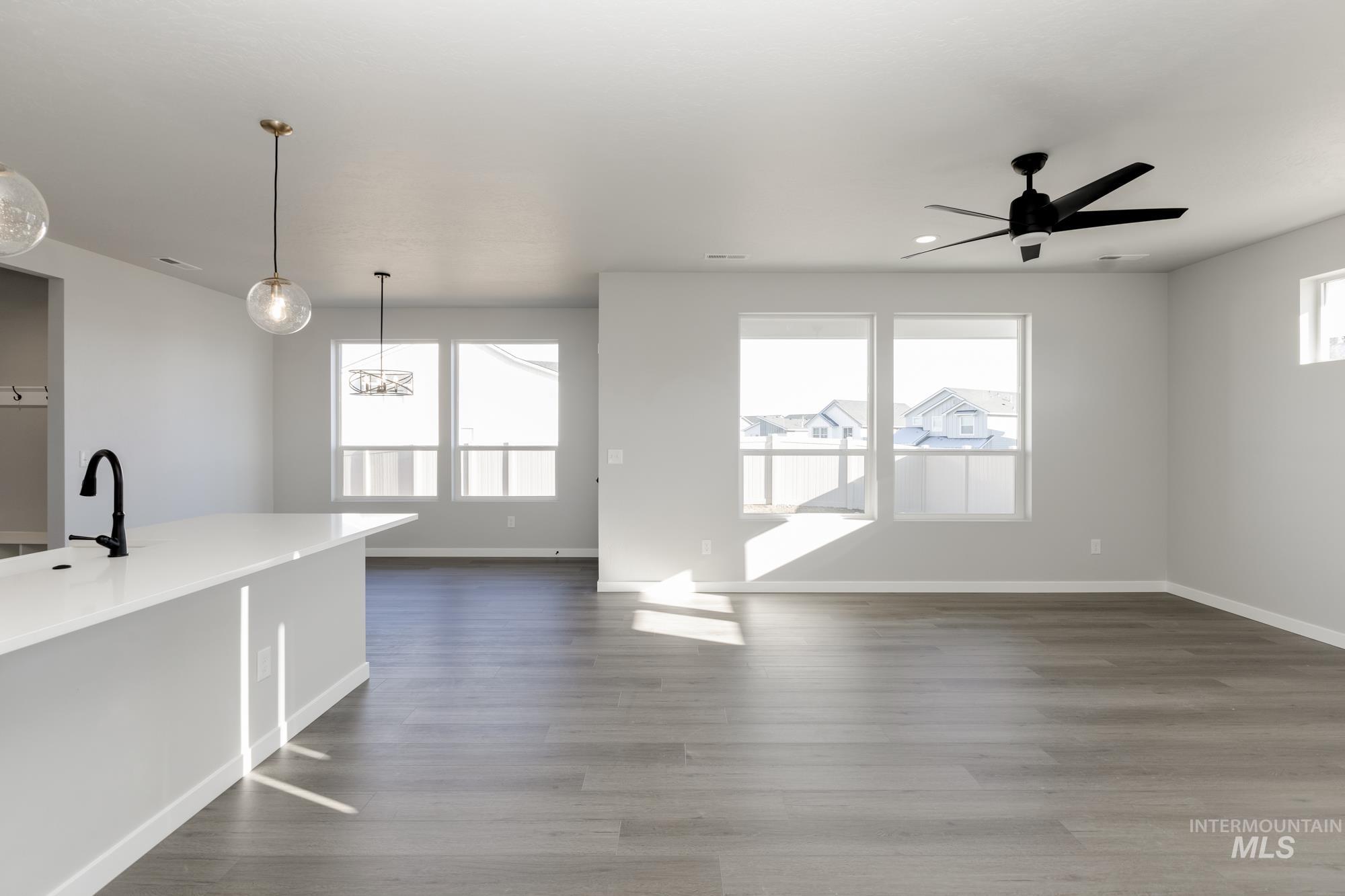 Unfurnished living room featuring dark wood-style flooring, a ceiling fan, and recessed lighting