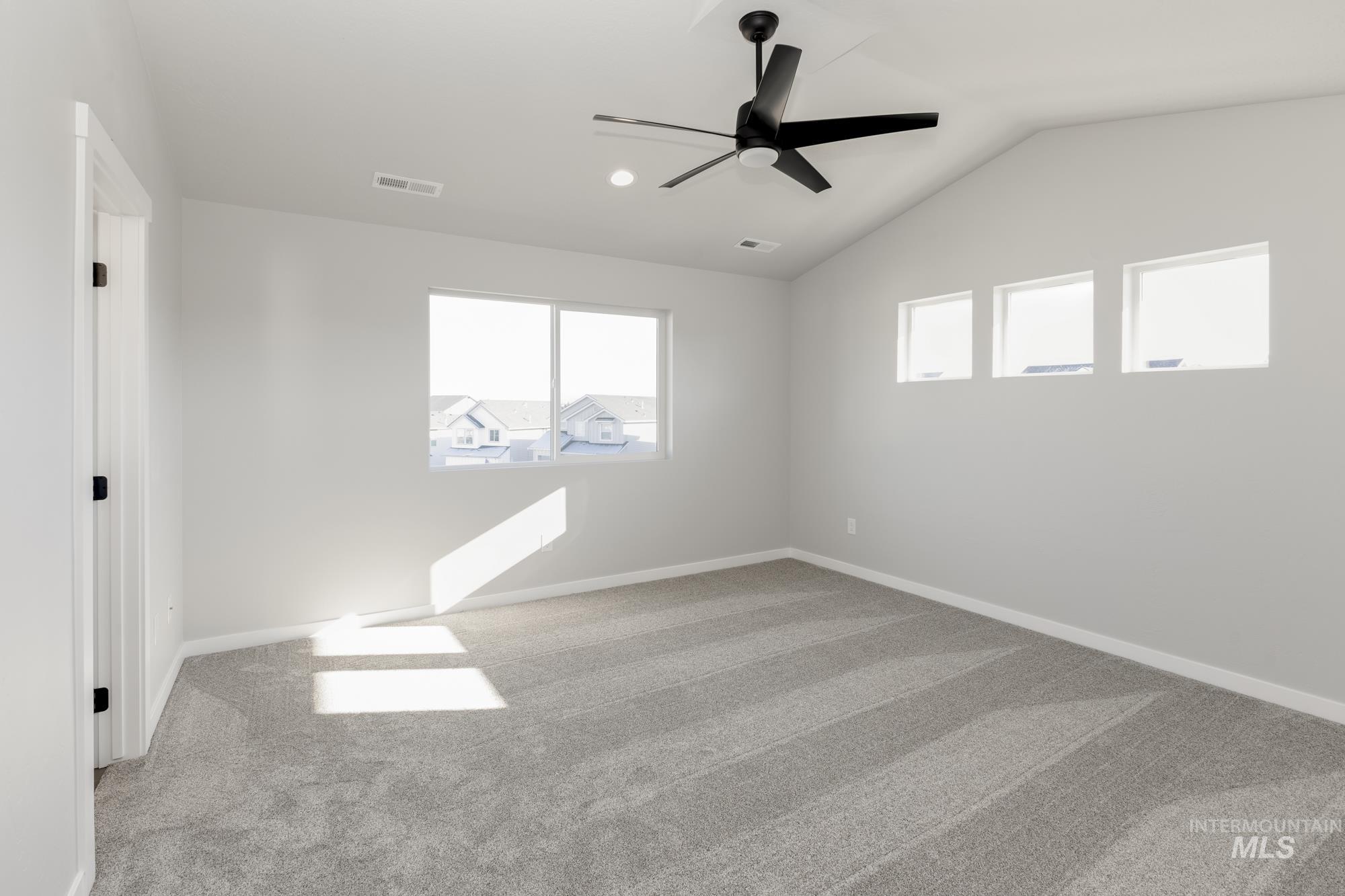 Unfurnished room with light colored carpet, vaulted ceiling, ceiling fan, and recessed lighting