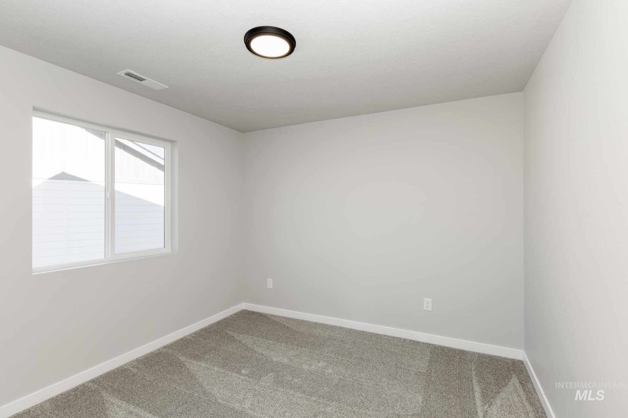 Spare room featuring carpet floors and baseboards