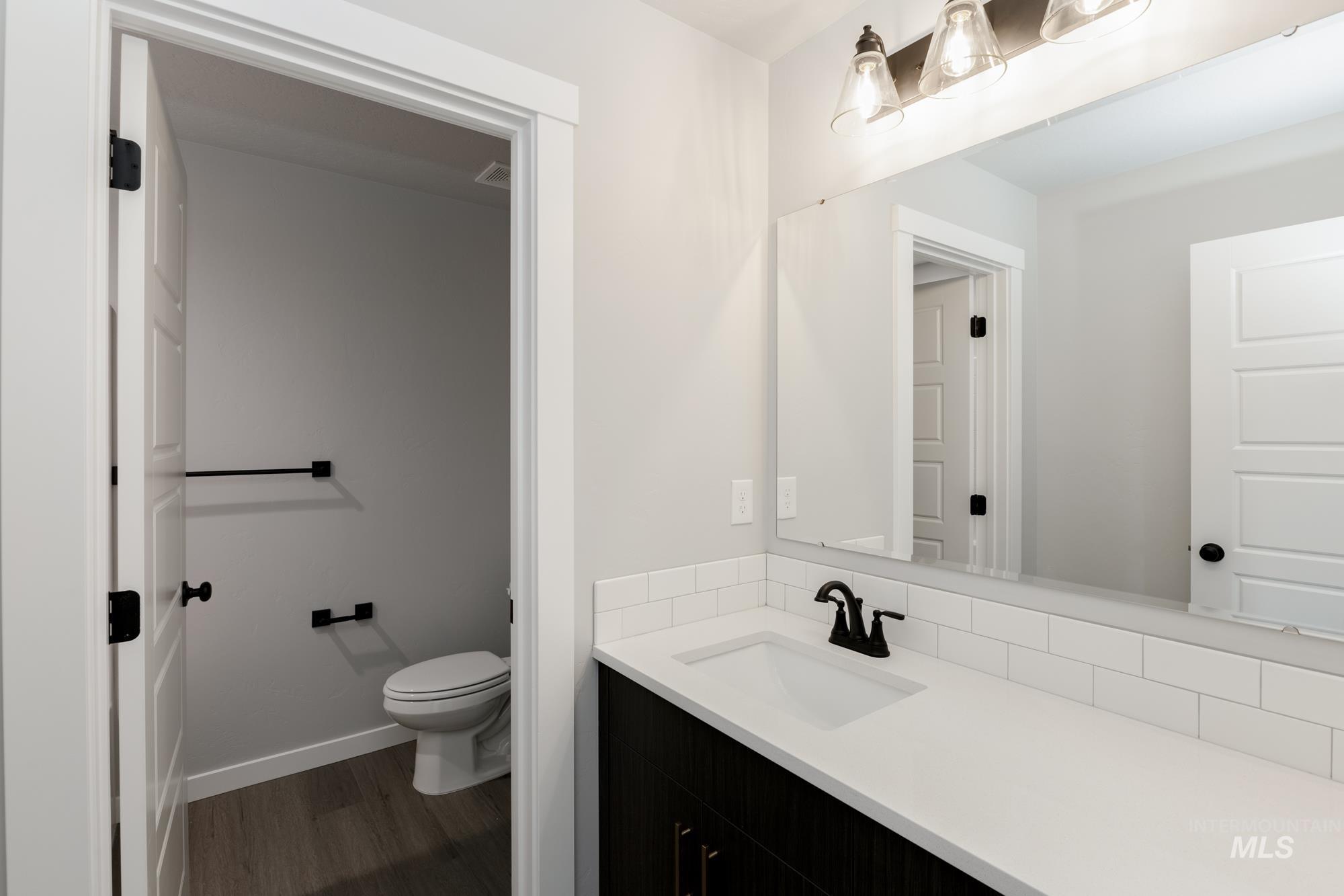 Half bath featuring vanity and dark wood-type flooring