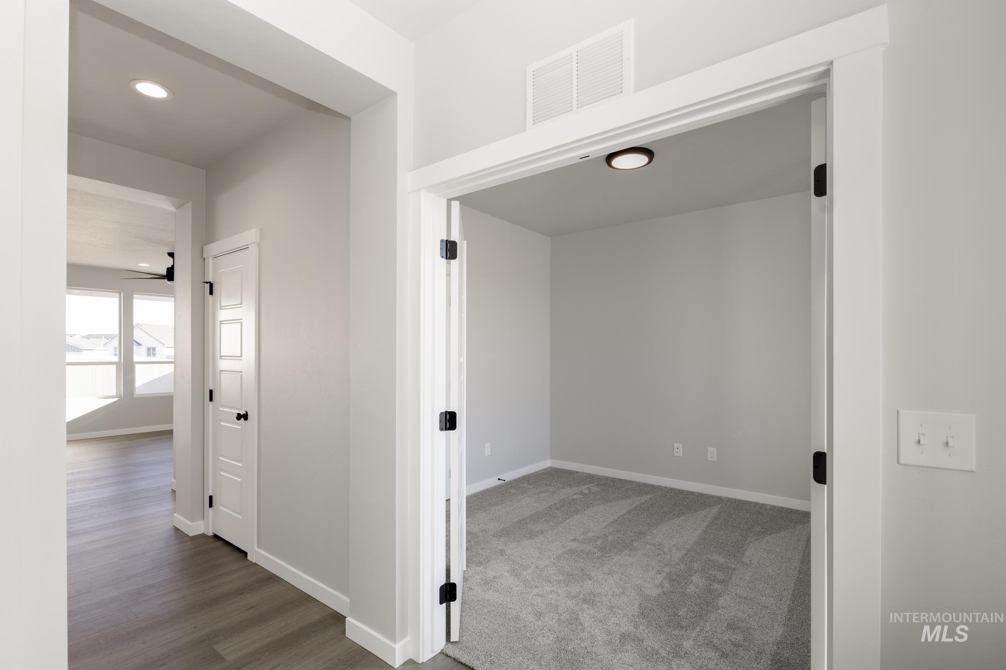 Corridor with recessed lighting, light wood finished floors, and light carpet