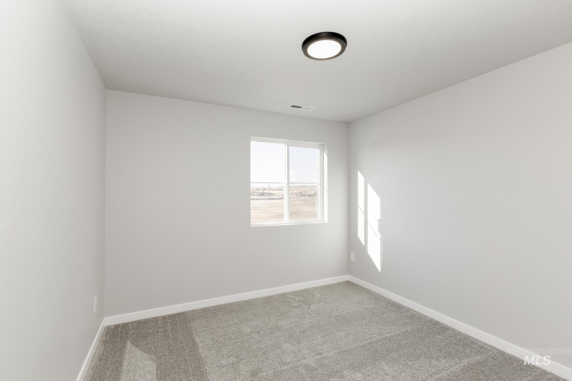 Empty room with carpet flooring and baseboards