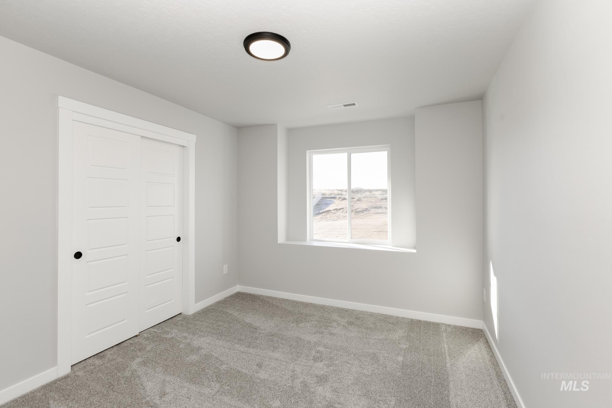 Unfurnished bedroom featuring light carpet and a closet
