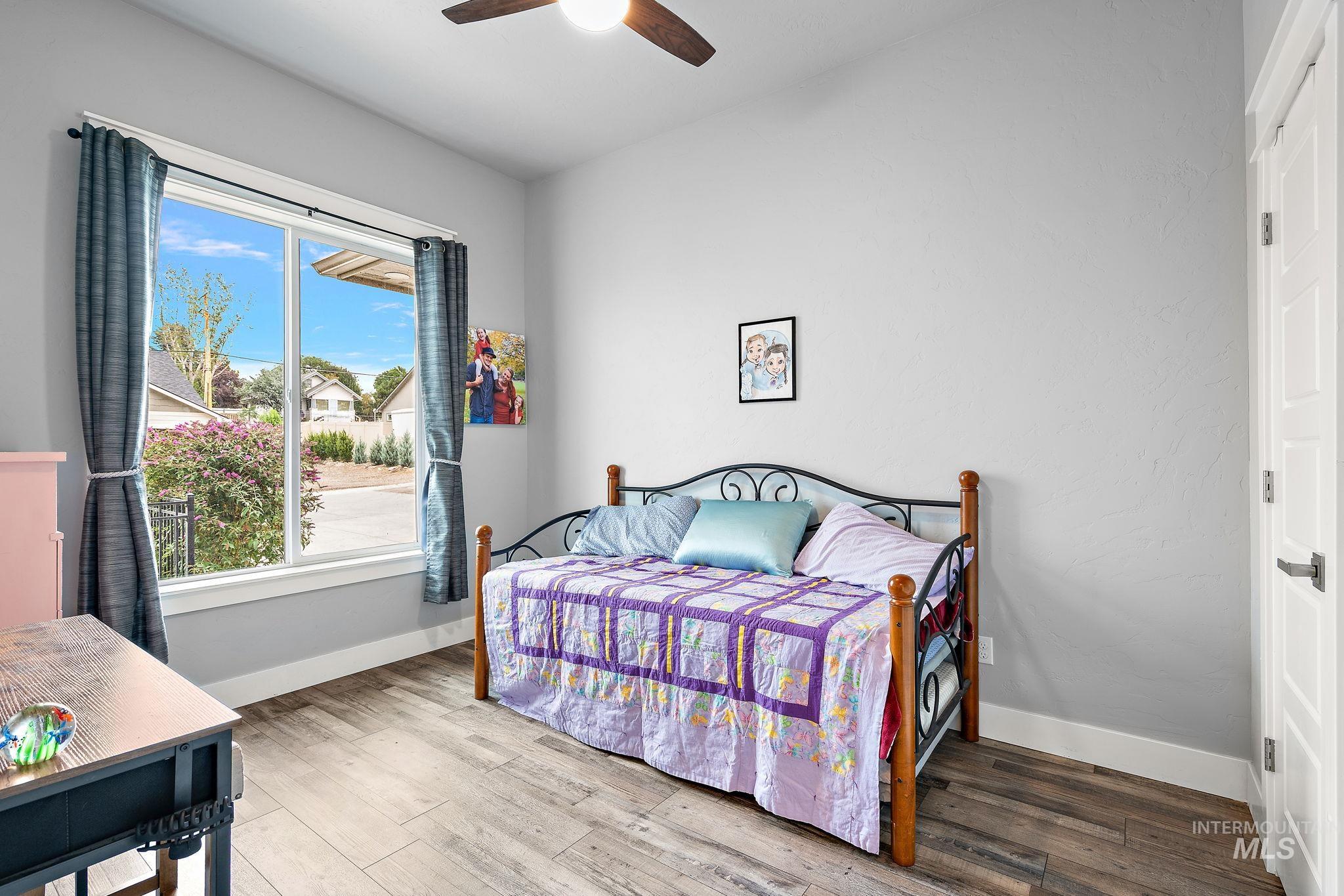 Bedroom with wood finished floors and a ceiling fan