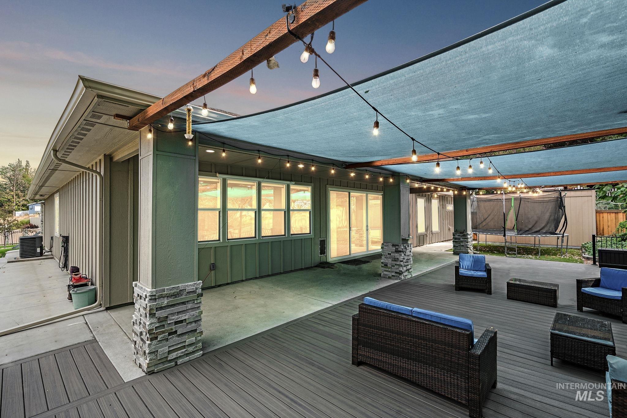 Deck at dusk with a trampoline, a patio, and an outdoor living space