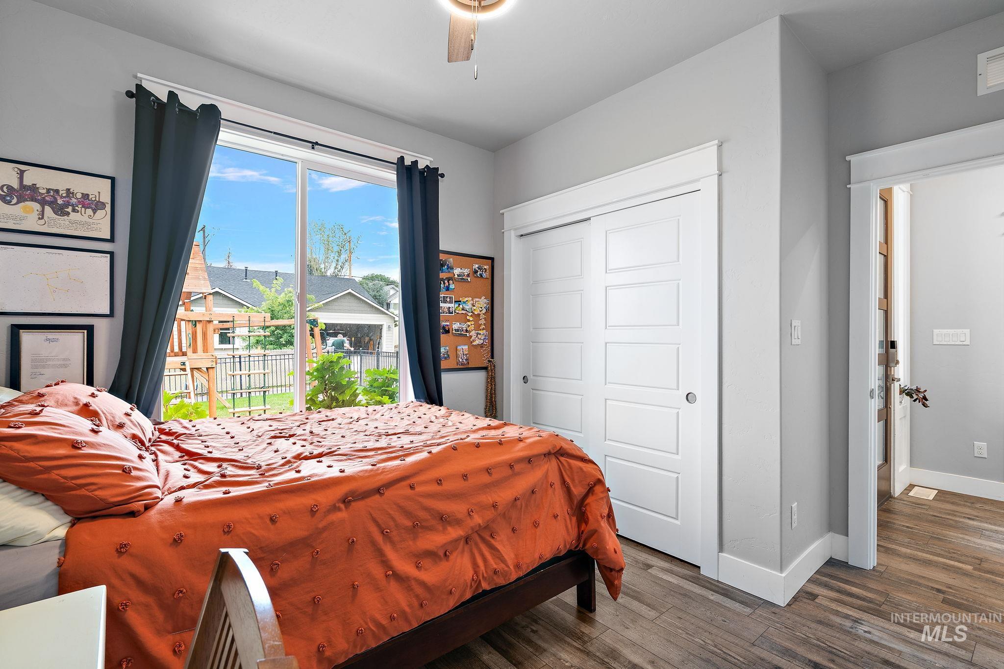 Bedroom featuring wood finished floors, a closet, access to outside, and a ceiling fan