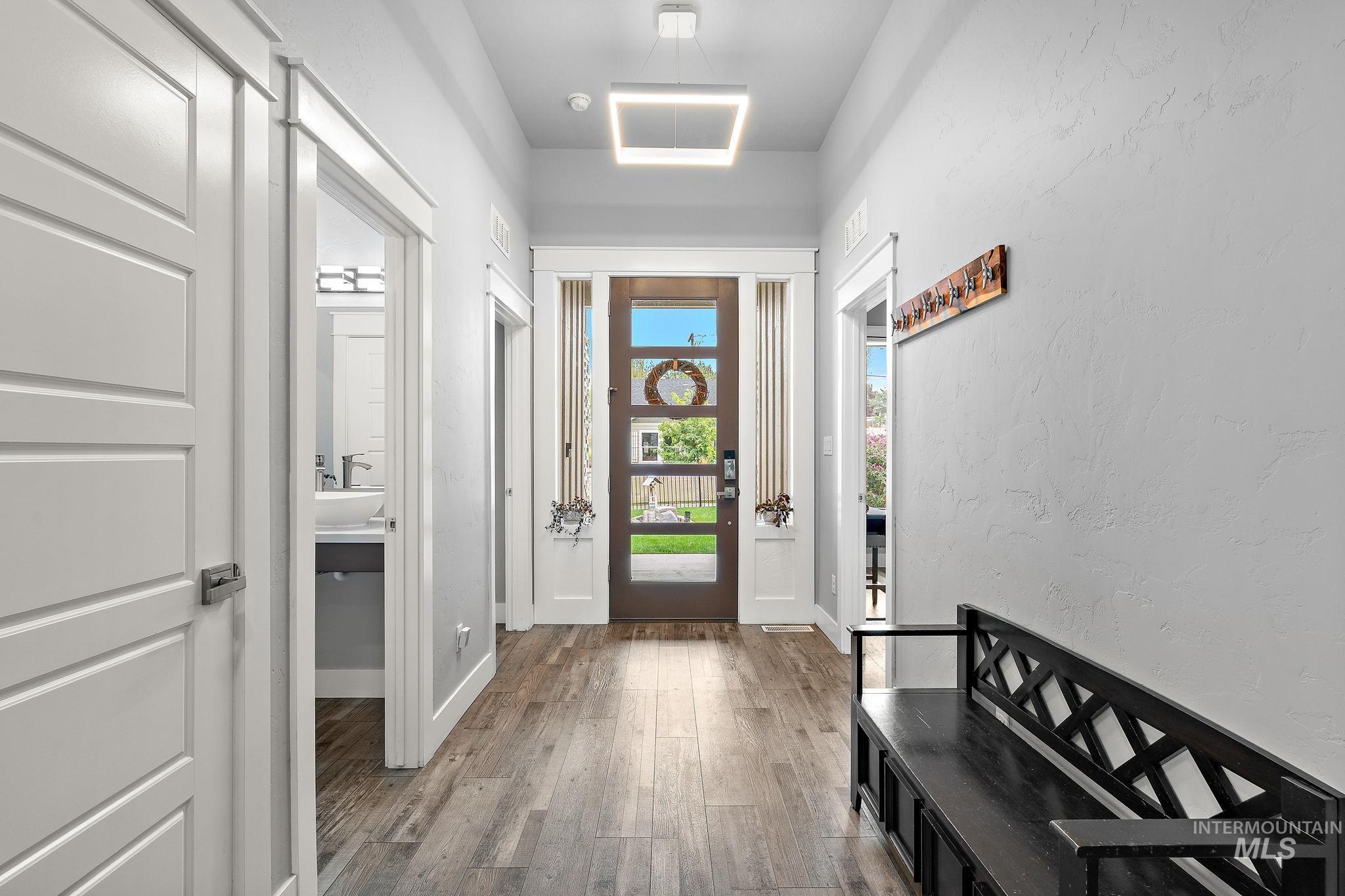 Entryway with wood finished floors and a textured wall