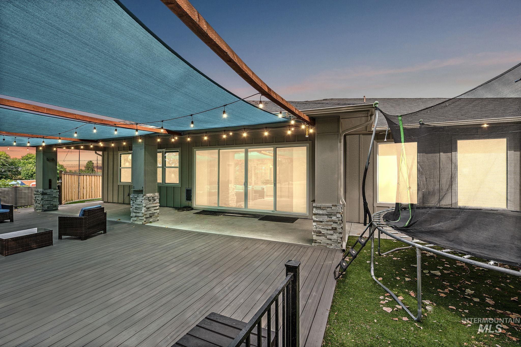 Deck at dusk with a trampoline and a patio area