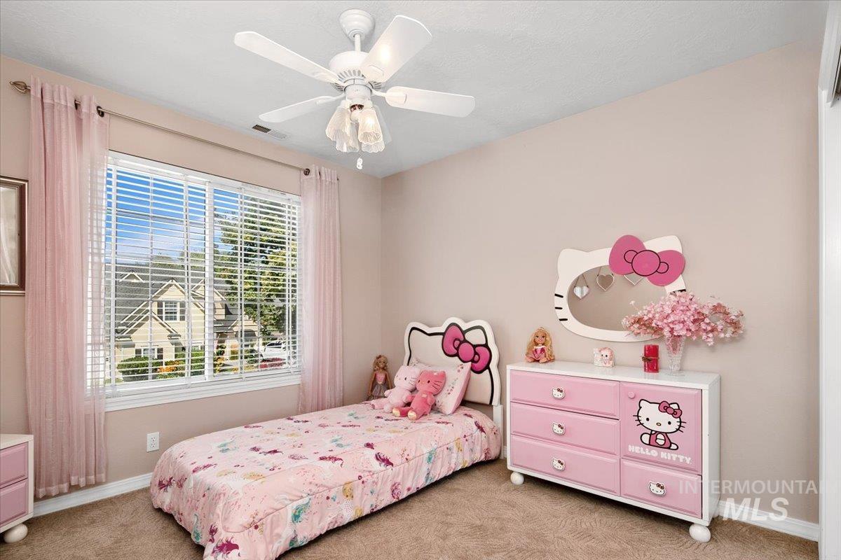 Carpeted bedroom featuring ceiling fan and baseboards