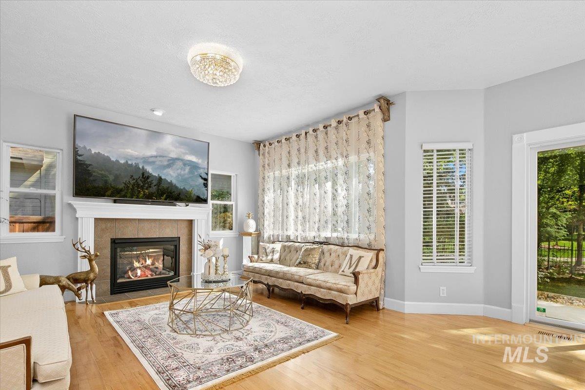 Living area with light wood-style floors, a fireplace, and a textured ceiling