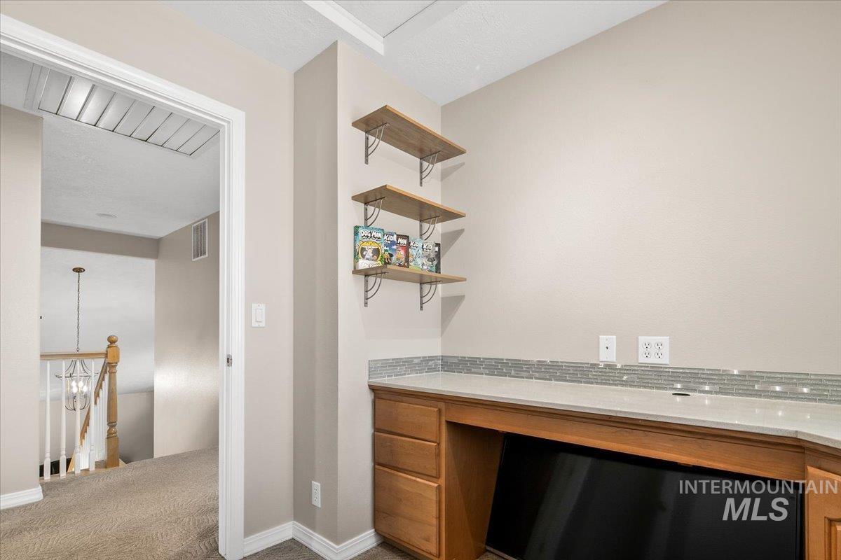 Unfurnished office with carpet and built in desk