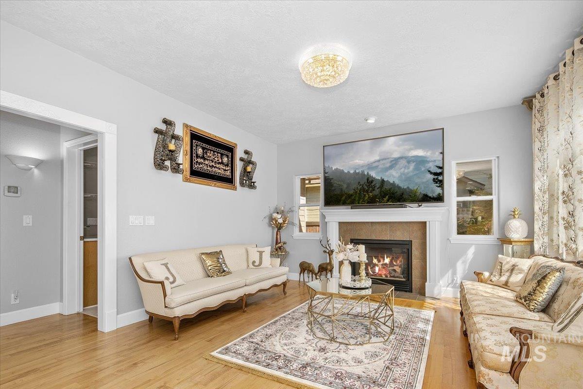 Living area with light wood-style flooring, a fireplace, and a textured ceiling