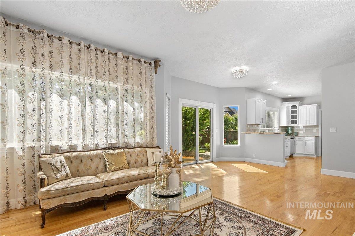 Living room featuring light wood-style flooring and a textured ceiling