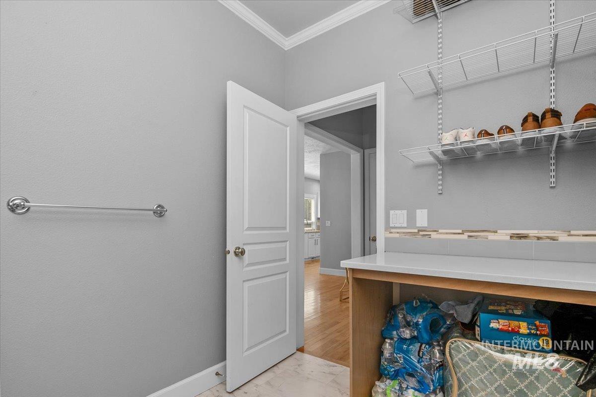 Laundry room featuring ornamental molding and baseboards