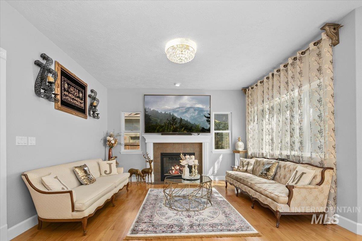 Living room featuring a tile fireplace, wood finished floors, and a textured ceiling