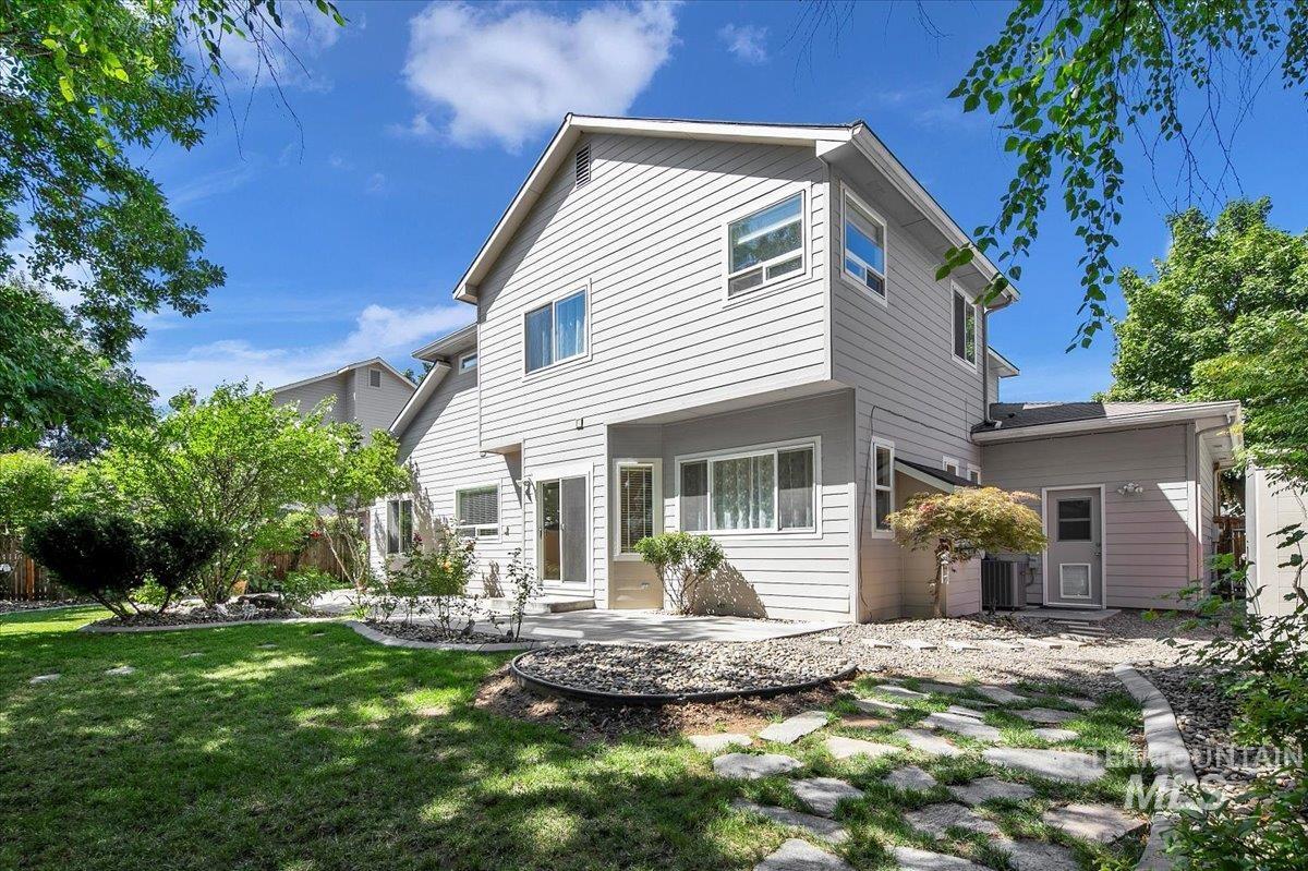 Back of property with a lawn and a patio