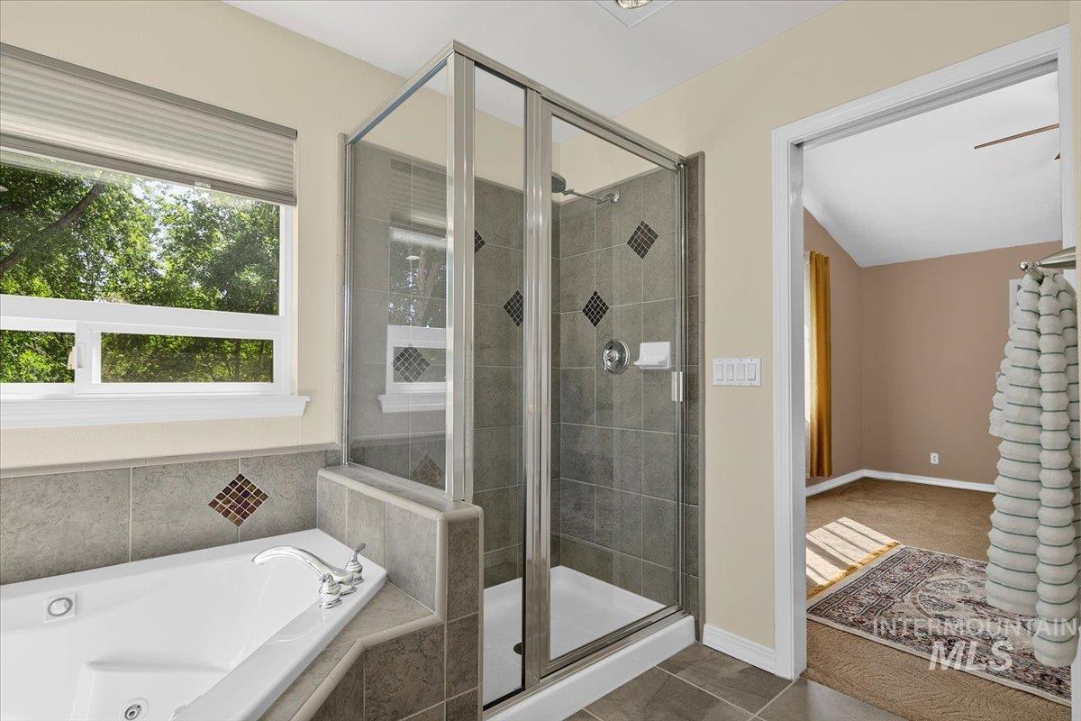 Full bath with a tub with jets, a stall shower, and tile patterned flooring